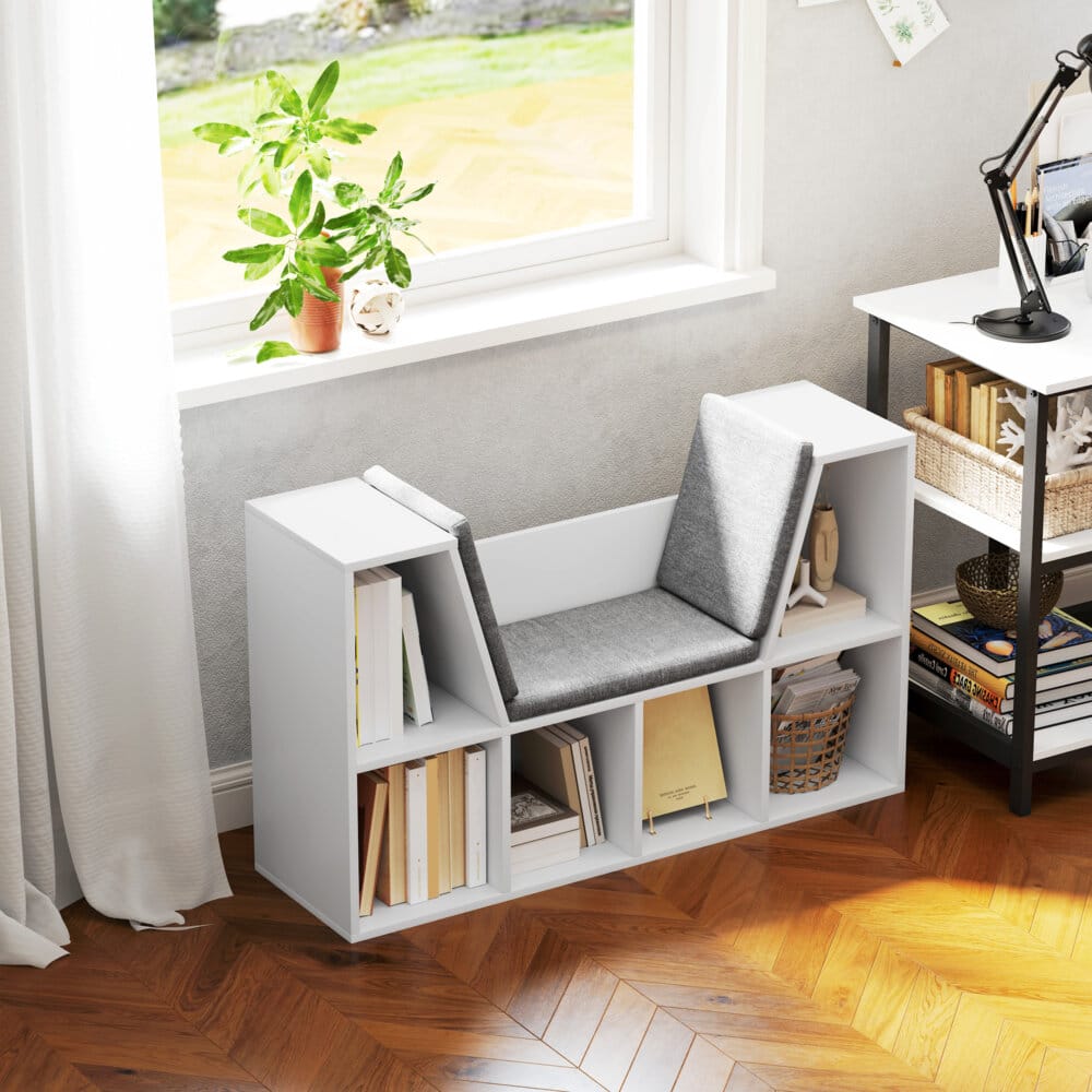 Ein weisses Bücherregal mit 6 Fächern und einem Sitzkissen in Leinenoptik.