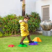 Buntes Kinderspielzeug in Form von rutschfesten Flusssteinen, bis 80kg belastbar. Es fördert das Gleichgewicht und kreatives Spiel im Kinderzimmer oder Garten.