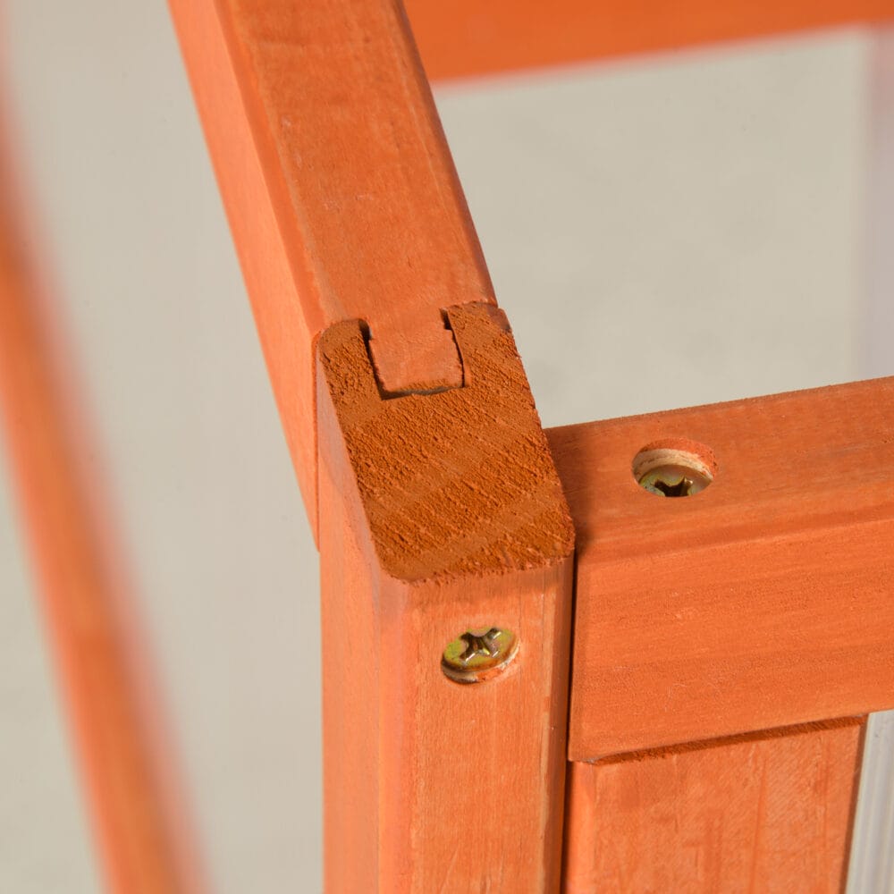 Wetterfestes oranges Frühbeet aus Holz und Polycarbonat, schützt Pflanzen vor Witterungseinflüssen und fördert das Wachstum.