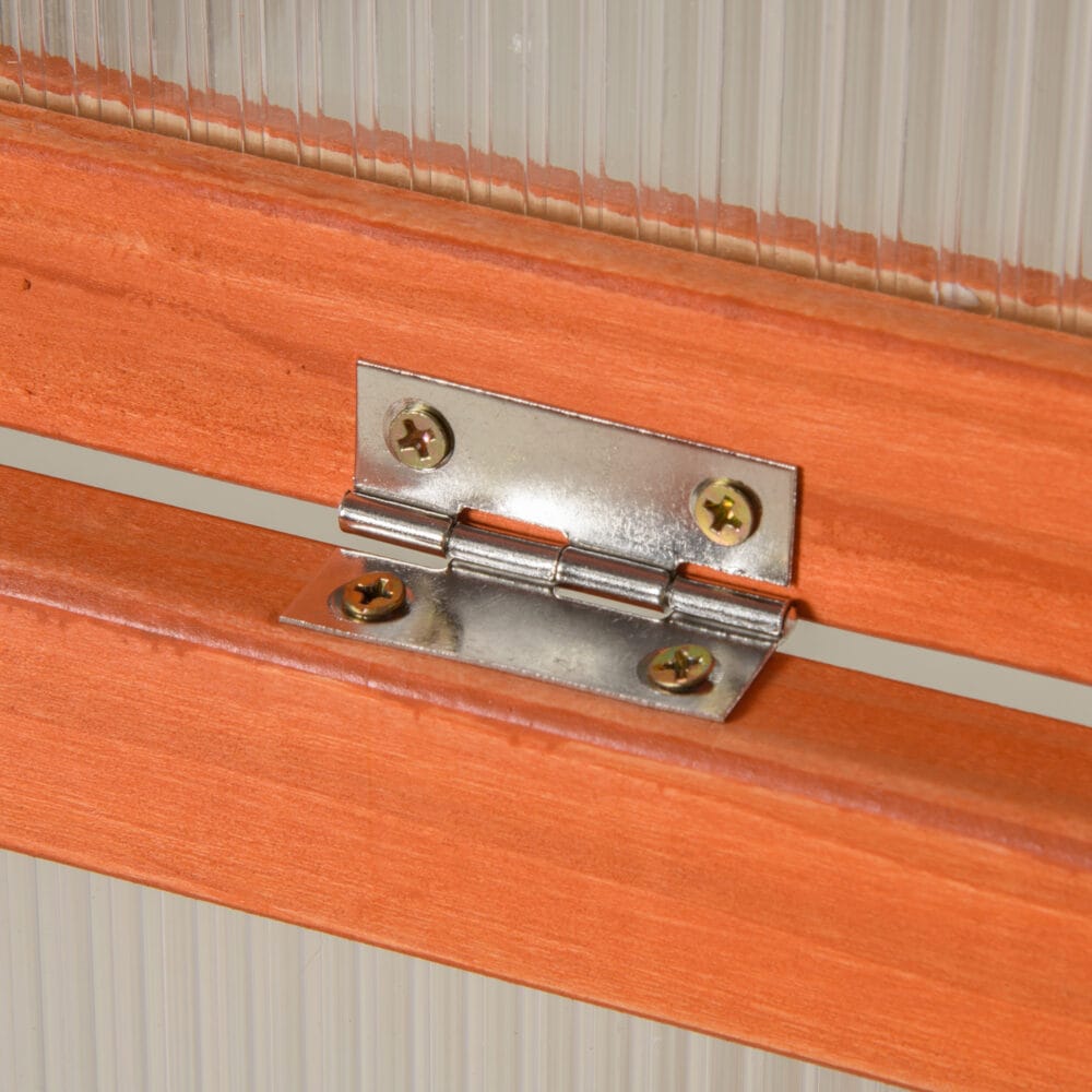 Wetterfestes oranges Frühbeet aus Holz und Polycarbonat, schützt Pflanzen vor Witterungseinflüssen und fördert das Wachstum.