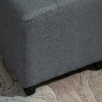 Ein grauer, quadratischer Fusshocker in Leinenoptik, Maße 35x35x35cm.