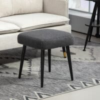 Ein dunkelgrauer, quadratischer Fusshocker in Kaschmir-Optik mit Stahlbeinen.