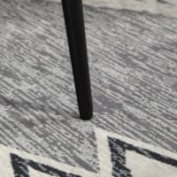 Ein dunkelgrauer, quadratischer Fusshocker in Kaschmir-Optik mit Stahlbeinen.