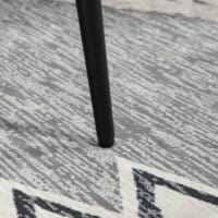 Ein hellgrauer, quadratischer Fusshocker in Kaschmir-Optik mit Stahlbeinen.