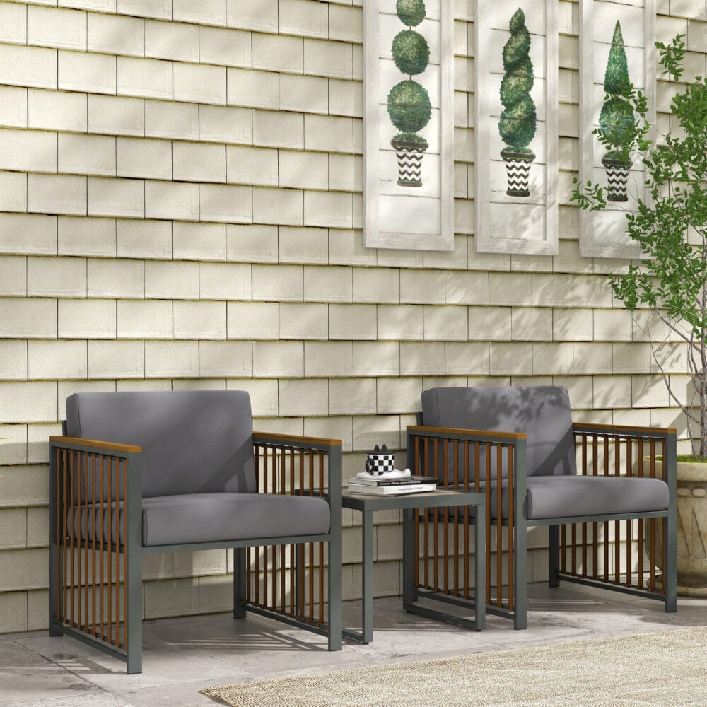 Dreiteiliges graues Gartenmöbel-Set mit Couchtisch und Kissen.