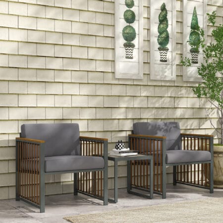 Dreiteiliges graues Gartenmöbel-Set mit Couchtisch und Kissen.