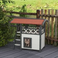 Weisses 2-stöckiges Katzenhaus aus Holz, mit Balkon und Treppe, eine charmante und funktionale Behausung für Katzen.