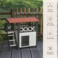 Weisses 2-stöckiges Katzenhaus aus Holz, mit Balkon und Treppe, eine charmante und funktionale Behausung für Katzen.