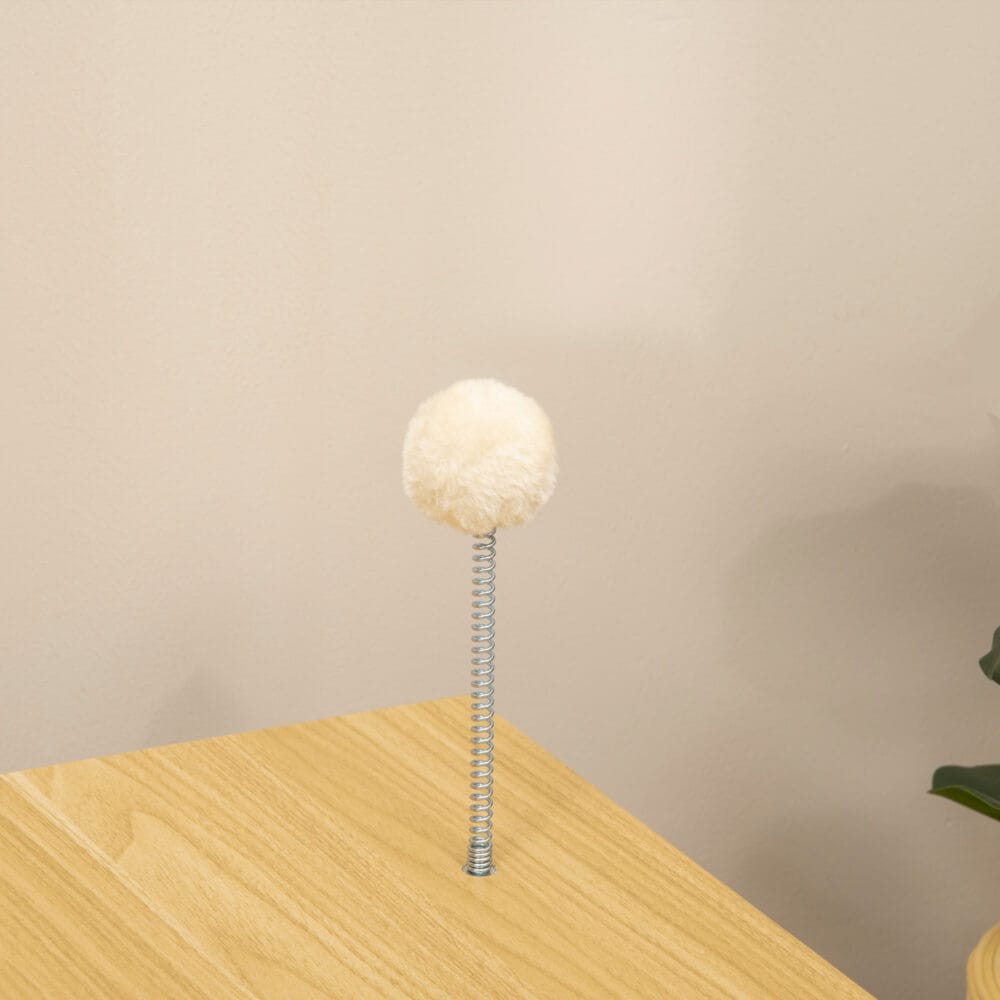 Beiges Katzenhaus im TV-Design mit Spielball und Kissen, ein origineller und gemütlicher Rückzugsort für Katzen.