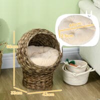 Dunkelbrauner Katzenkorb aus Rattan mit Kissen aus Wasserhyazinthe, bietet eine natürliche und bequeme Schlafgelegenheit.
