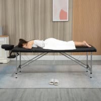 Eine schwarze Massageliege, klappbar, mit 7 Zonen und höhenverstellbar.