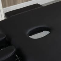 Eine schwarze Massageliege, klappbar, mit 7 Zonen und höhenverstellbar.