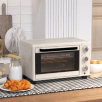 Ein cremeweisser Minibackofen und Ofen mit 21 Litern Fassungsvermögen, Temperaturbereich 100-230 Grad Celsius und Drehspiess.
