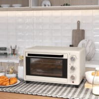 Ein cremeweisser Minibackofen und Ofen mit 21 Litern Fassungsvermögen, Temperaturbereich 100-230 Grad Celsius und Drehspiess.