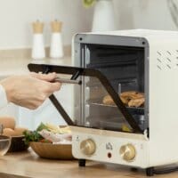 Ein cremeweisser Minibackofen und Umluftofen mit 15 Litern Fassungsvermögen und Temperaturbereich 60-230 Grad Celsius.