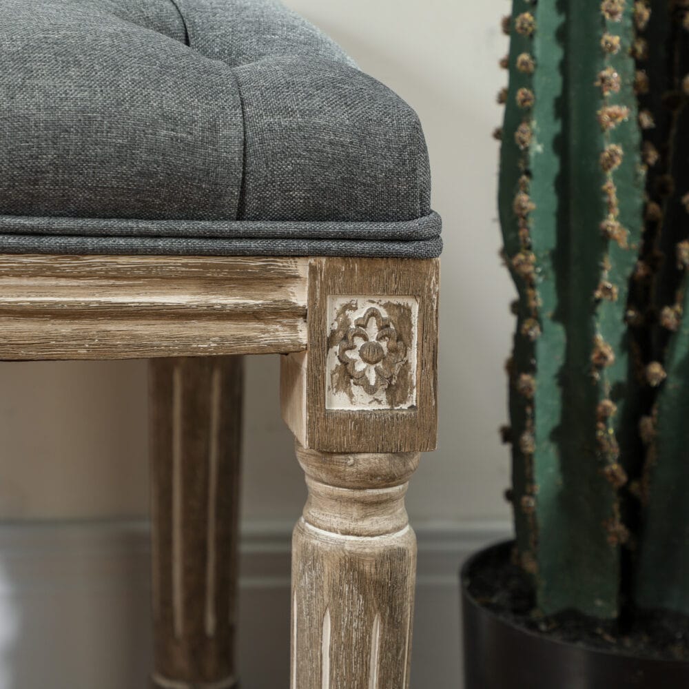 Graue Polsterbank im Vintage-Stil mit eleganter Knopfverzierung. Ein zeitloses Möbelstück für klassische Einrichtungen.