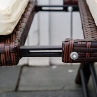 Braunes, klappbares Polyrattan-Gartensofa für zwei Personen.