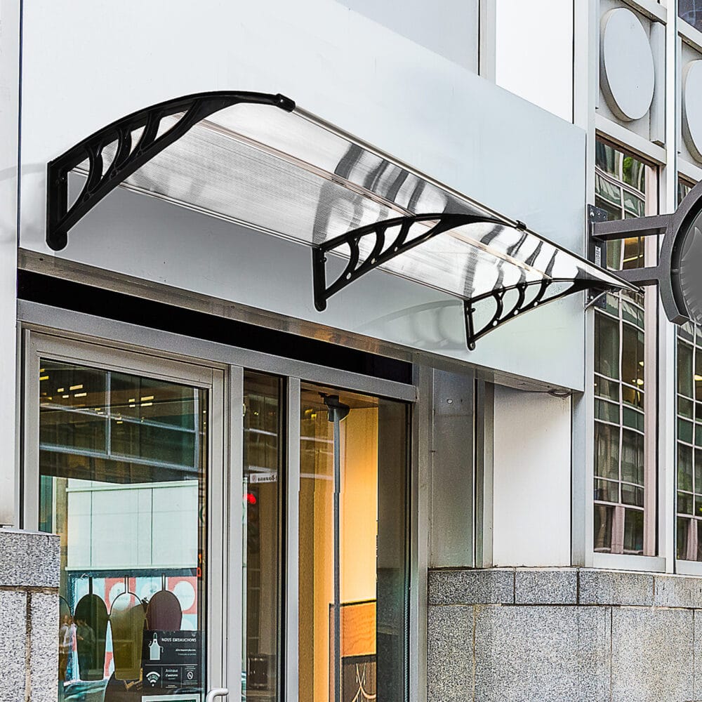 Transparentes Pultvordach für die Haustür, aus Polycarbonat und Aluminium, bietet modernen Wetterschutz.