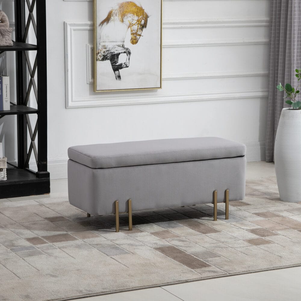 Hellgraue Sitzbank mit integriertem Stauraum, ideal für das Wohnzimmer, um Decken und Kissen ordentlich zu verstauen.