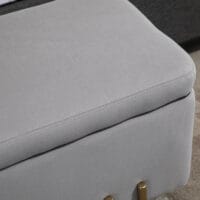 Hellgraue Sitzbank mit integriertem Stauraum, ideal für das Wohnzimmer, um Decken und Kissen ordentlich zu verstauen.
