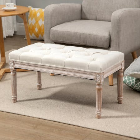 Ein cremeweisser Sitzhocker mit gepolstertem Sitz und Holzbeinen in Leinenoptik.