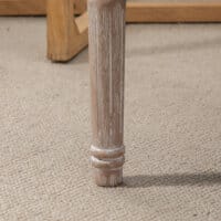 Ein cremeweisser Sitzhocker mit gepolstertem Sitz und Holzbeinen in Leinenoptik.
