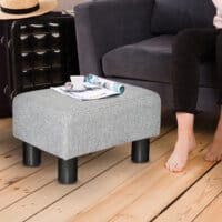 Ein grauer, rechteckiger Sitzhocker in Leinenoptik, belastbar bis 150kg.