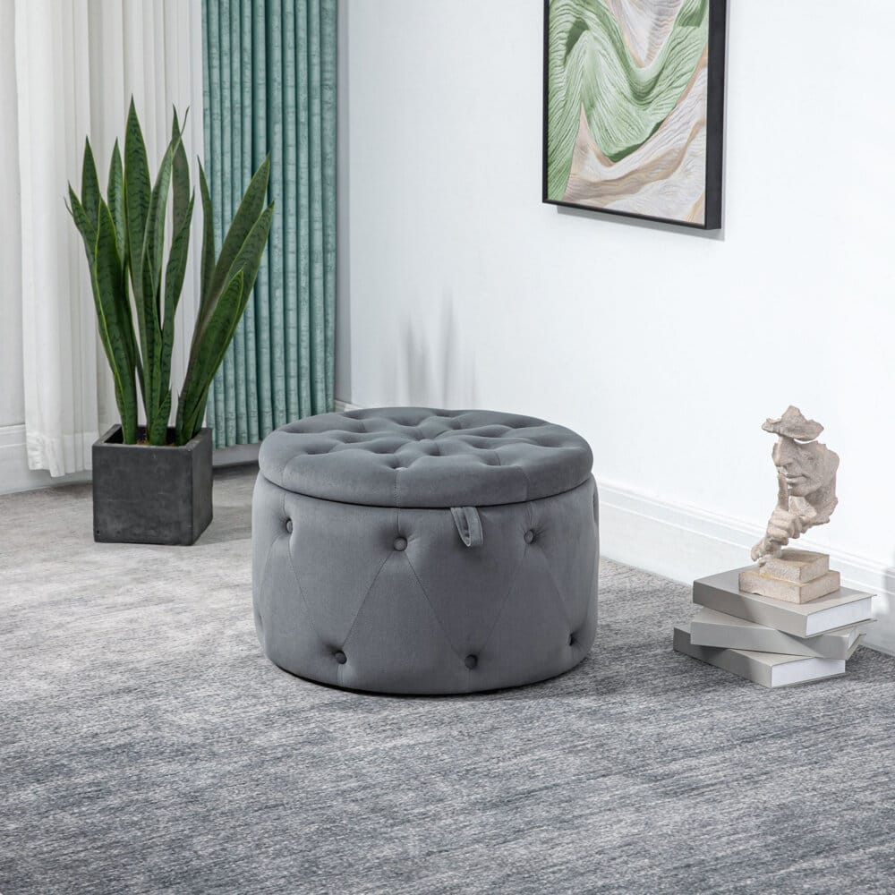 Ein grauer Sitzhocker mit Stauraum in runder Form und Samtoptik.