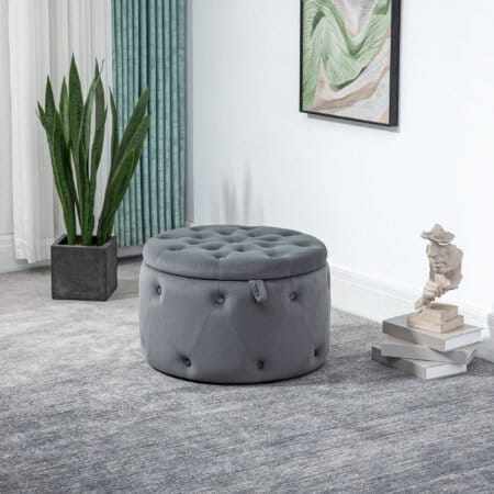 Ein grauer Sitzhocker mit Stauraum in runder Form und Samtoptik.