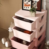 Rosa Spielzeugkommode mit vier offenen Fächern, speziell für das Kinderzimmer entworfen, um Spielzeug und Bastelmaterialien übersichtlich zu organisieren.